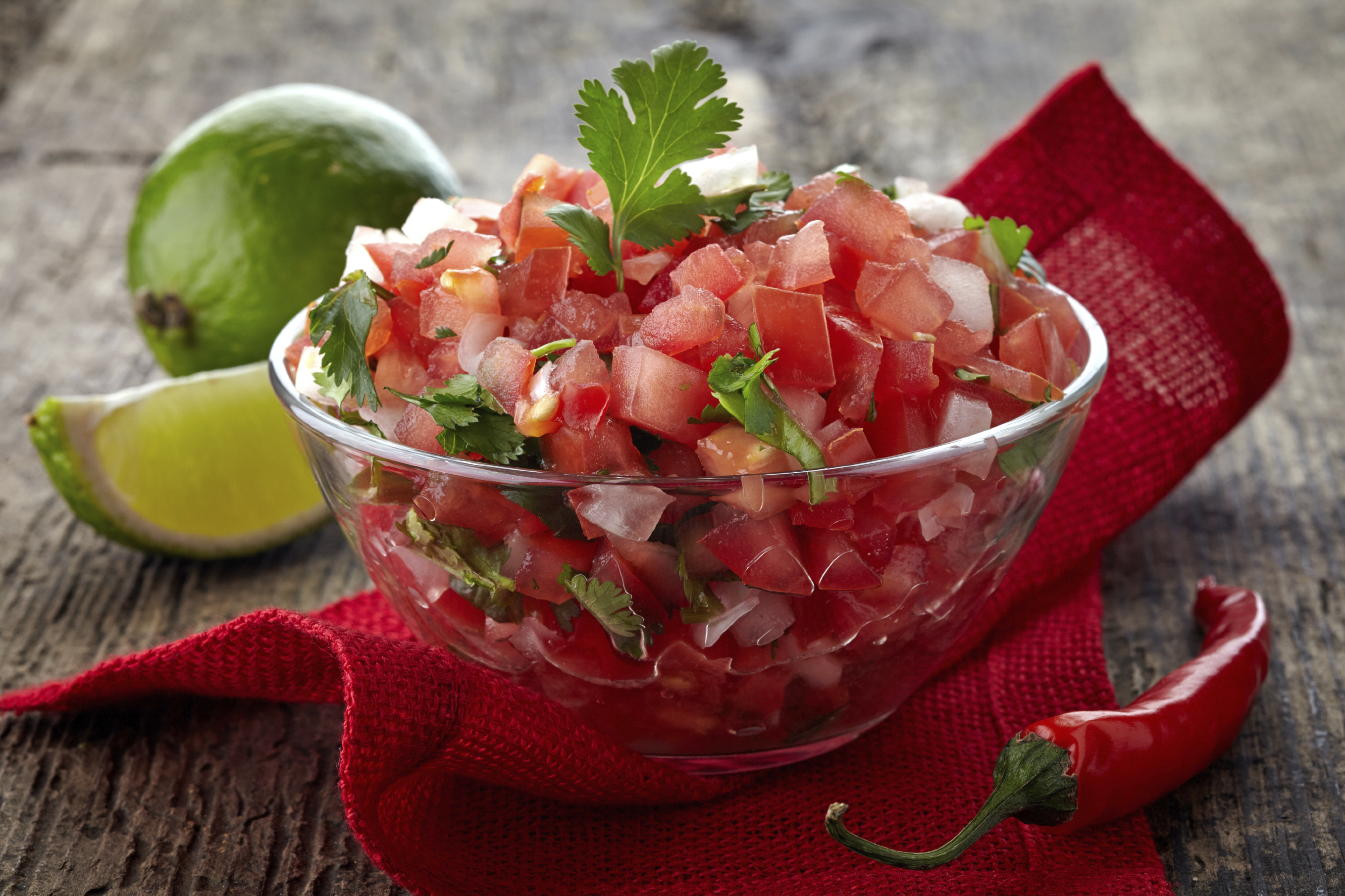 Chunky salsa in a bowl with limes on the side