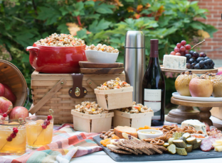 A fall dinner party spread with a charcuterie board, fresh apples and wine.